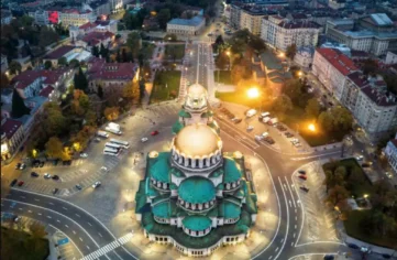 Аерофотография на храм-паметник Александър Невски в София, осветен през нощта.